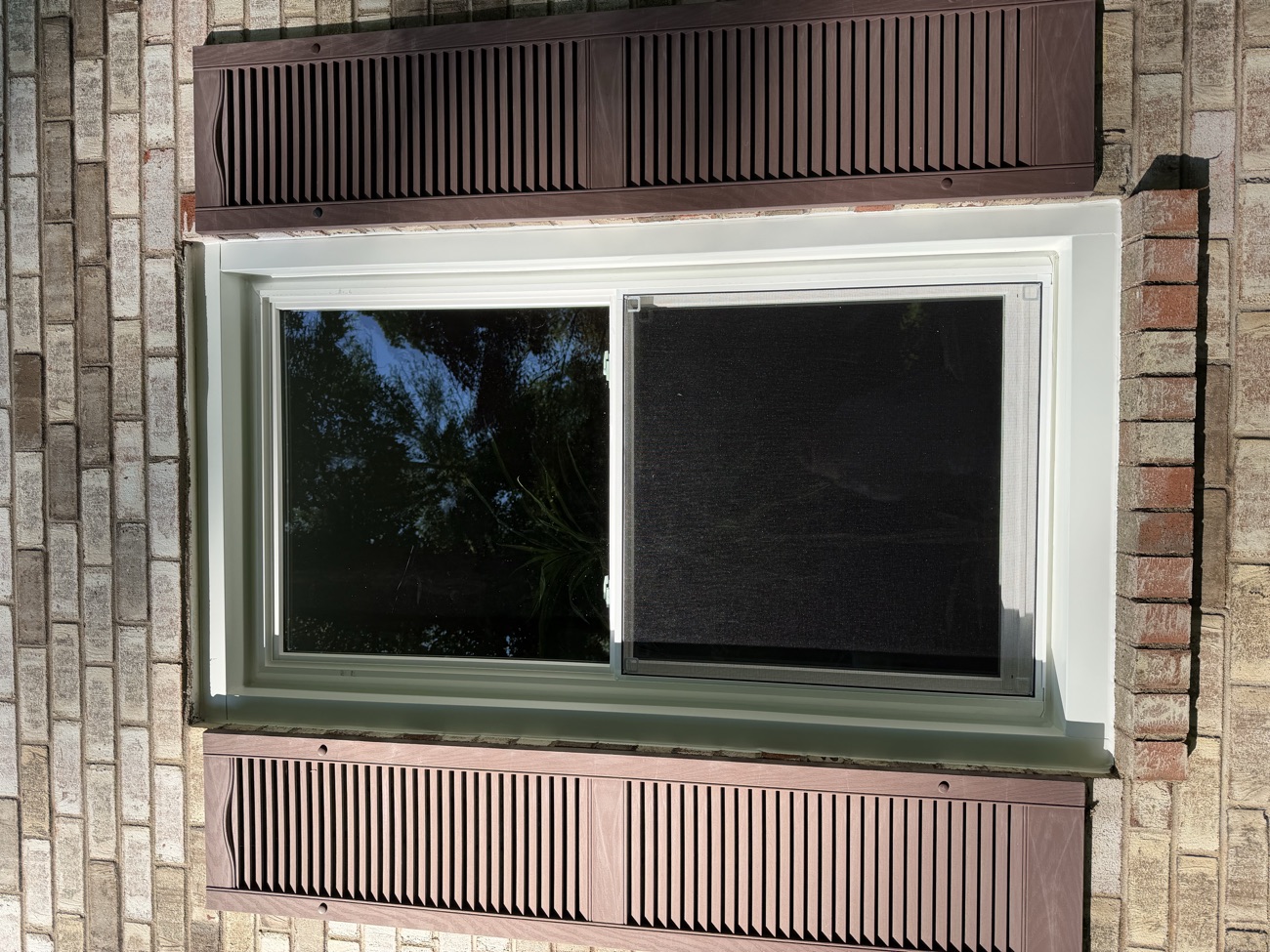 New double-hung window framed by shutters on the elevation.